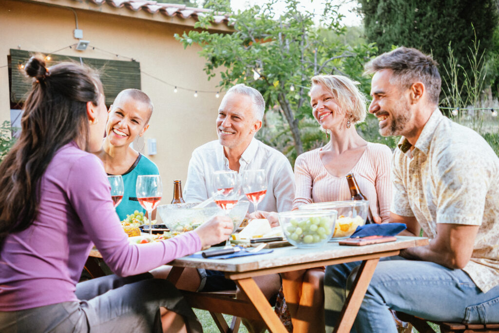 Gruppe erwachsener Menschen sitzen zusammen am Tisch und lernen mit Spaß Italienisch