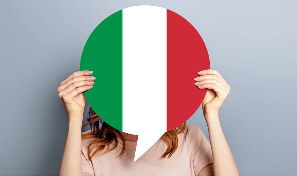 Studentin hält leere weiße Sprechblase mit italienischer Flagge isoliert über grauem Studiohintergrund Frau hält ein rundes Informationsblatt Dialog