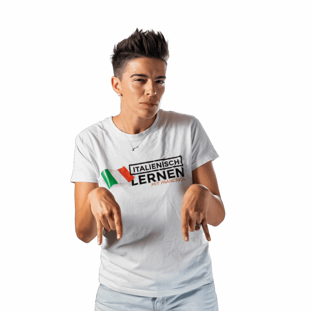 Eine Person mit kurzen dunklen Haaren, die ein weißes "Italienisch Lernen mit Francesca"-T-Shirt trägt, gestikuliert mit beiden Händen, macht die "Corna"-Geste und zeigt nach unten.