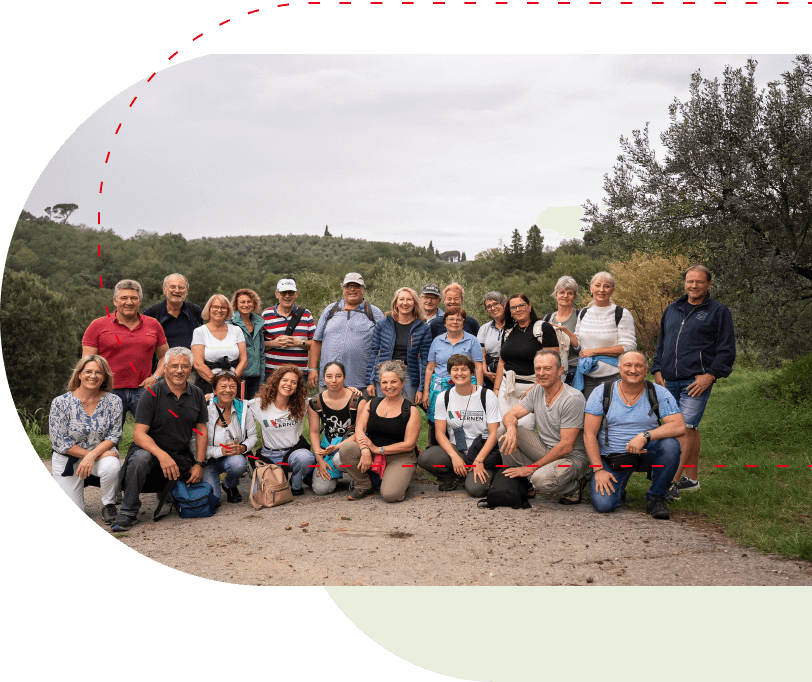 Gruppe von Menschen, die zwischen den toskanischen Hügeln posiert.