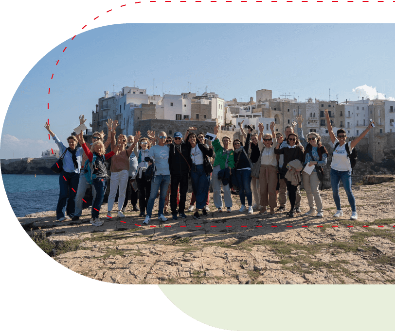 Gruppe von Menschen, die in Polignano a Mare in Apulien glücklich lächeln.