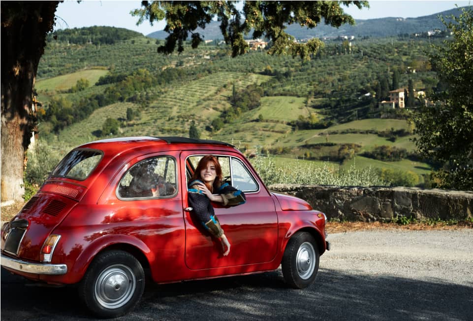 Roter Fiat 500 in toskanischer Hügellandschaft