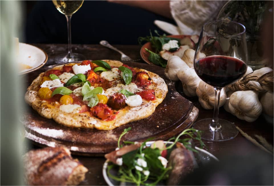 Pizza mit Tomaten, Mozzarella und Rotwein