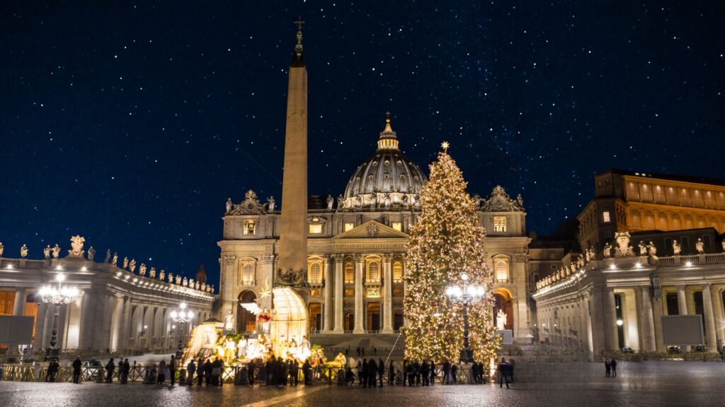 Der Petersplatz bei Nacht fängt den Zauber von Weihnachten in Italien ein, mit einem großen Weihnachtsbaum, einer Weihnachtskrippe und dem beleuchteten Petersdom unter dem Sternenhimmel.