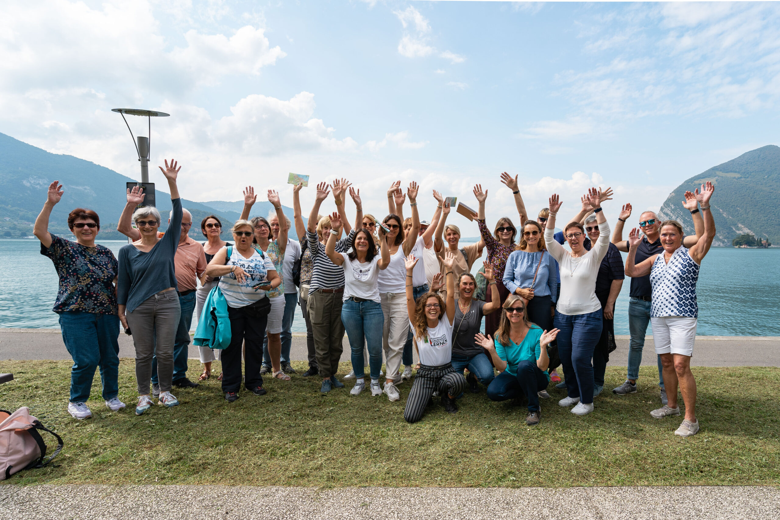 Eine Gruppe von Menschen mkit ausgestreckten Armen, auf einer Sprachreise in Italien.